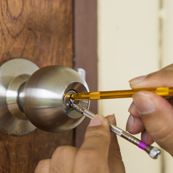 Technician repairing a damaged door lock for a Charleston homeowner